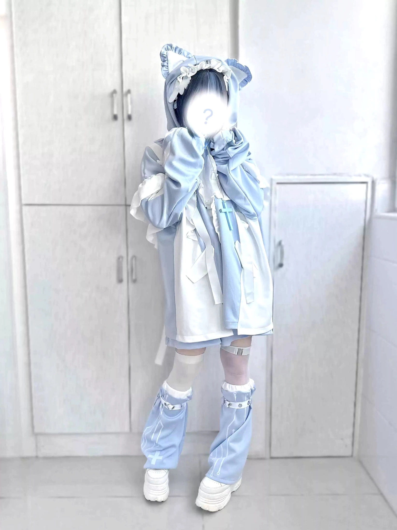 Side-front angle of blue-white tenshi kaiwai coat set showcasing cross decorative appliqué, flounce trim on shoulders, bandaged thigh-highs and light blue platforms