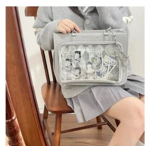 Silver checkered ita bag worn on lap with transparent display window and anime print decorations worn by girl in school uniform
