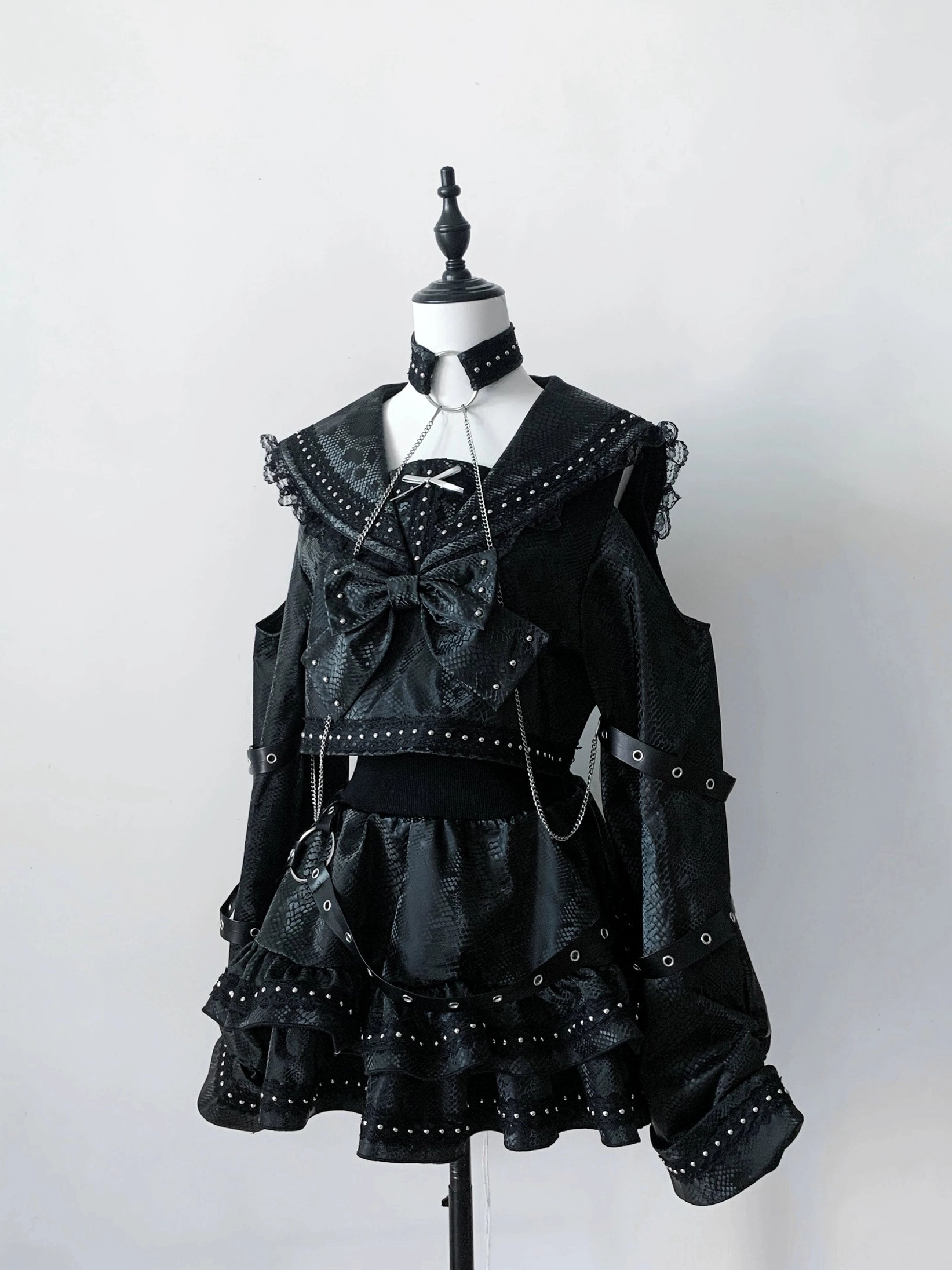 Black embossed texture gothic outfit set front static view on mannequin with rivet trims chain details and structured sailor collar design