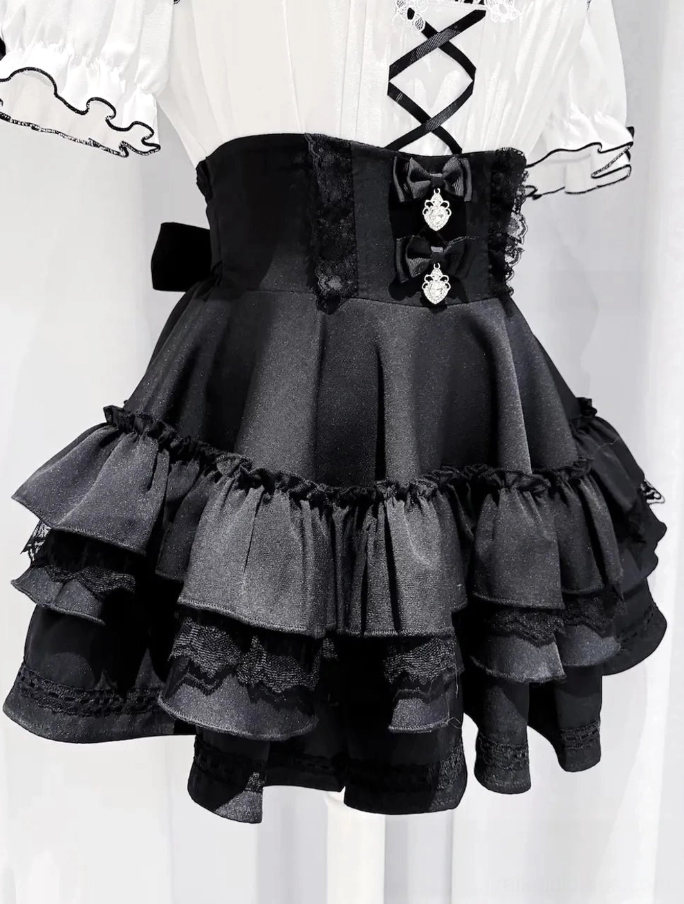 Solid black Jirai Kei tiered ruffle skirt full view showcasing silhouette and dramatic cascading hem layers