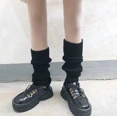 Solid black Y2K leg warmers with ribbed knitted fabric slouchy style front low view platform shoes indoor floor lower body