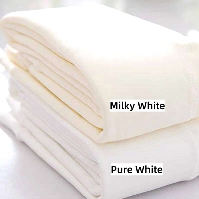 Two folded solid color footed tights packs in pure white and milky white displayed on minimalist tabletop, flat lay product shot showing neatly stacked pairs, smooth plain fabric texture