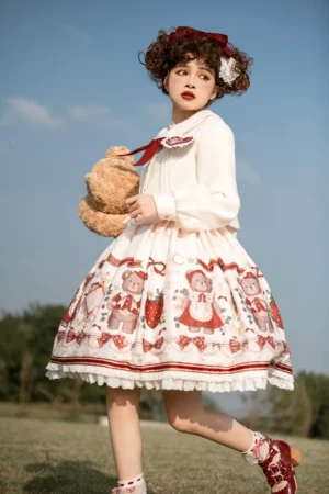 Cute teddy bear lolita dress strawberry print three-quarter angle jirai kei fashion model holding plush bear prop grass field