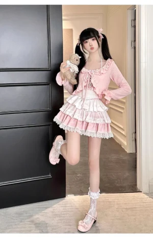 Sweet lolita pink cardigan skirt two-piece outfit set with ruffled trim details, model posing with leg lift