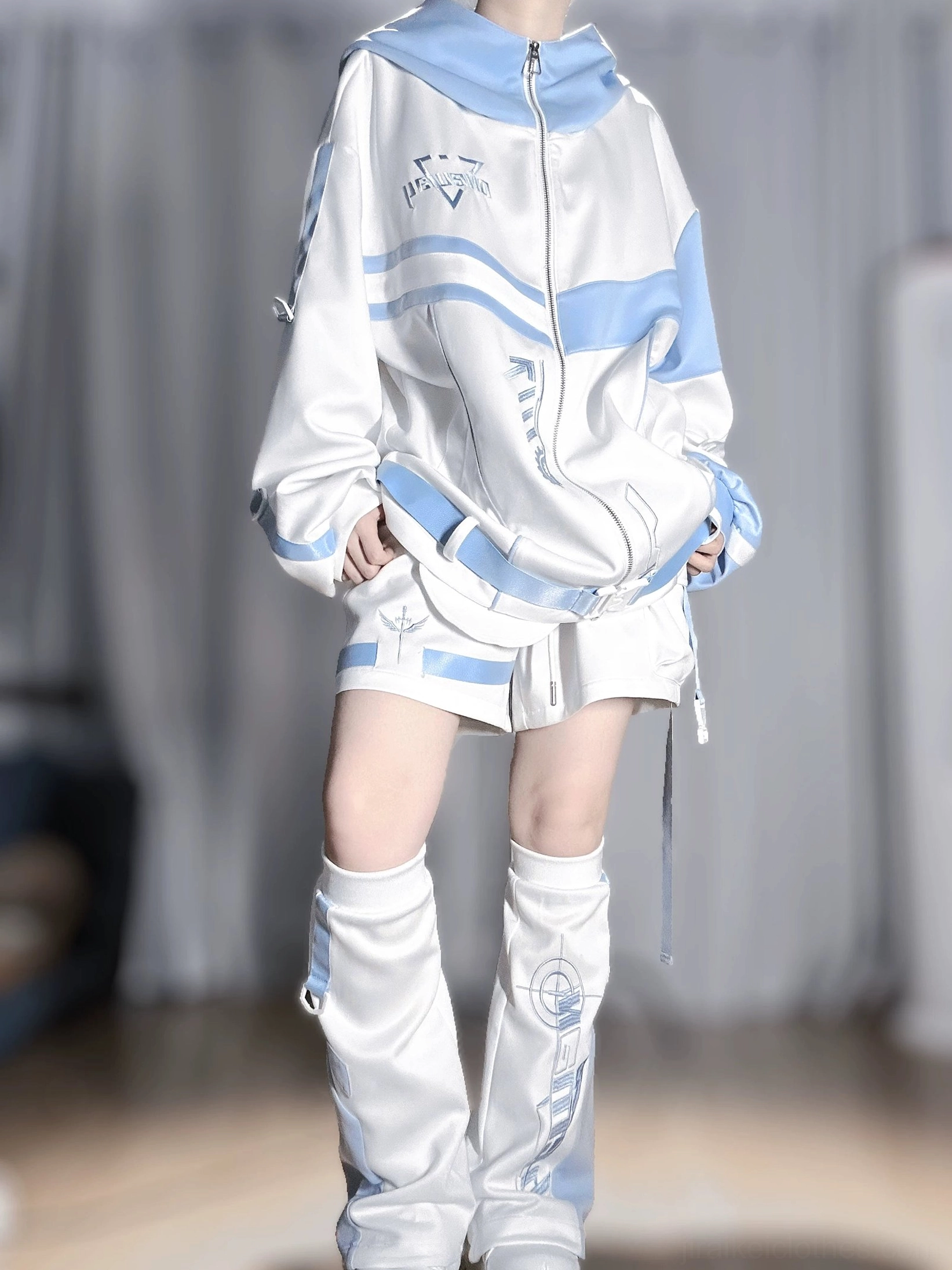 Techwear zip-up hoodie jacket front top view with chest embroidery logos, full metal zipper closure, oversized hood, and coordinating shorts on model