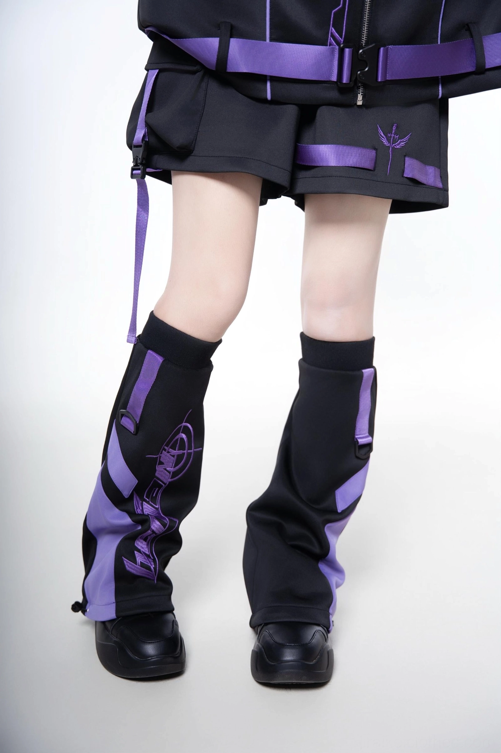 Techwear leg warmers set in black and purple - showing adjustable elastic construction and how they coordinate with oversized jacket