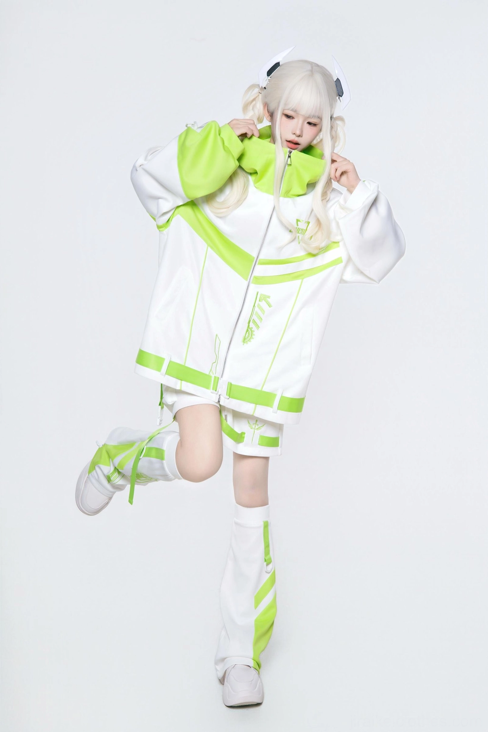 Neon green and white techwear hoodie set with leg warmers - dynamic action pose with lifted leg showing loose casual fit