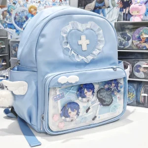 Kawaii blue itabackpack with transparent collection pocket displayed on desktop with anime figures, featuring angel wing side accents and heart lace cross ornament