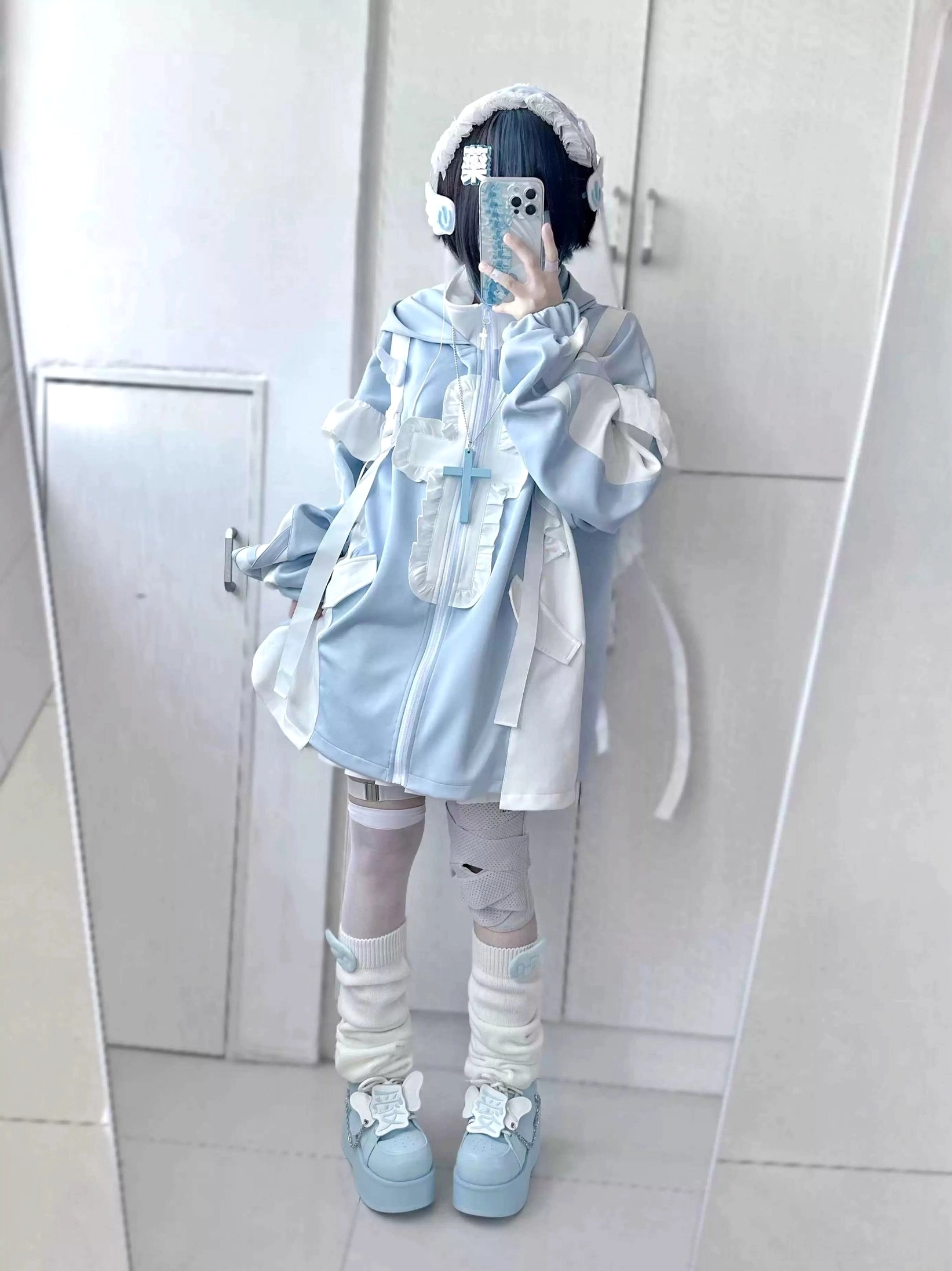 Mirror selfie showcasing blue-white tenshi coat with drawstring details, cross decorative elements, bandaged leg styling, leg warmers and complete coordinate presentation