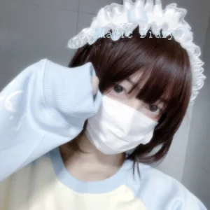 Tenshi Kaiwai angel wing lace headdress with white ruffled trim and light blue accents front view on model with brown short hair