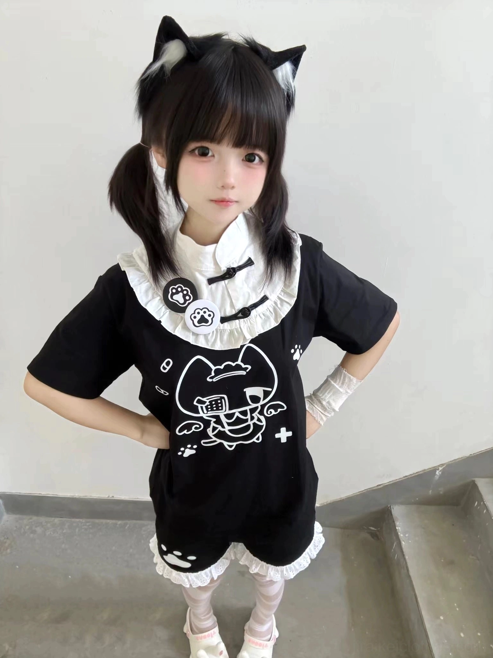 Black Tenshi Kaiwai cat ear themed cotton T-shirt with white ruffled stand collar and paw badges front standing view staircase