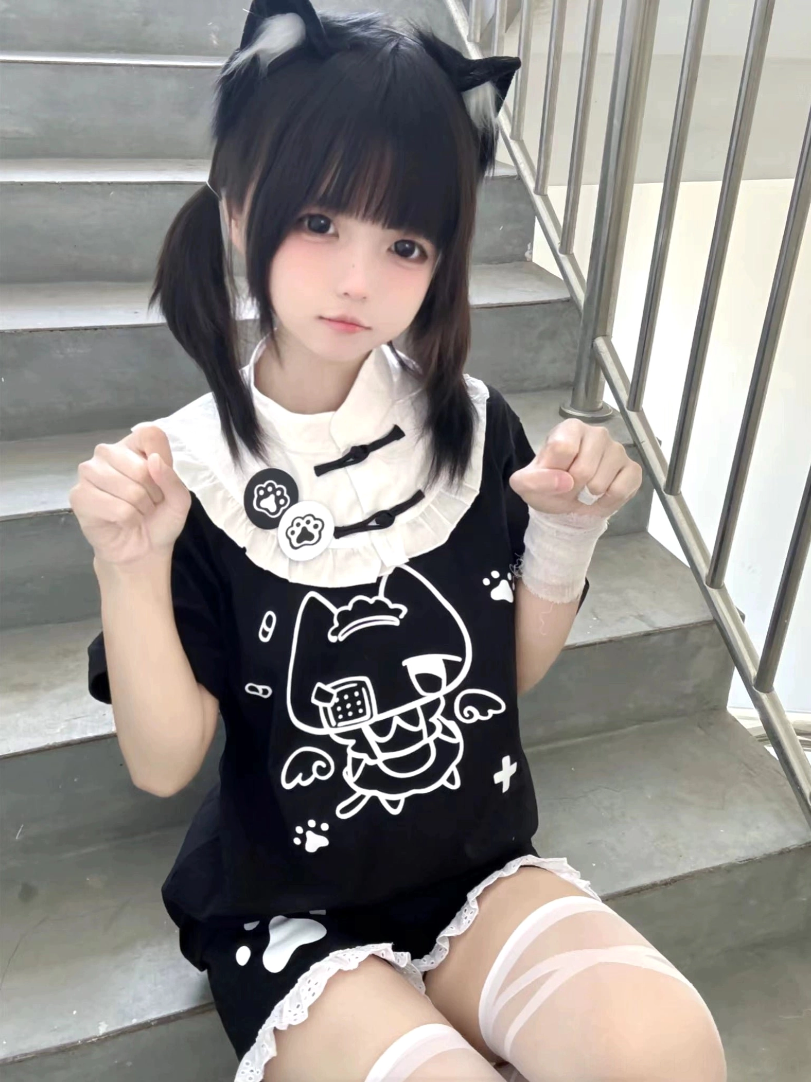Black Tenshi Kaiwai cat-themed cotton T-shirt sitting front view cartoon cat print with staircase background