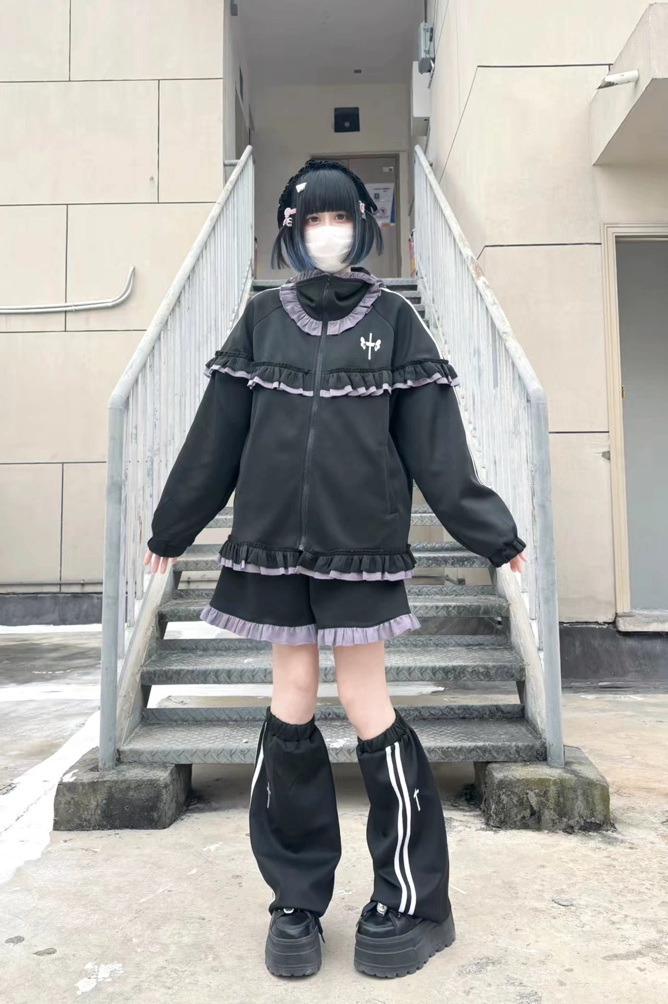 Black-purple ruffle Tenshi Kaiwai Jirai Kei set with striped leg warmers, frill trim shorts and loose zip-up jacket outdoor staircase styling