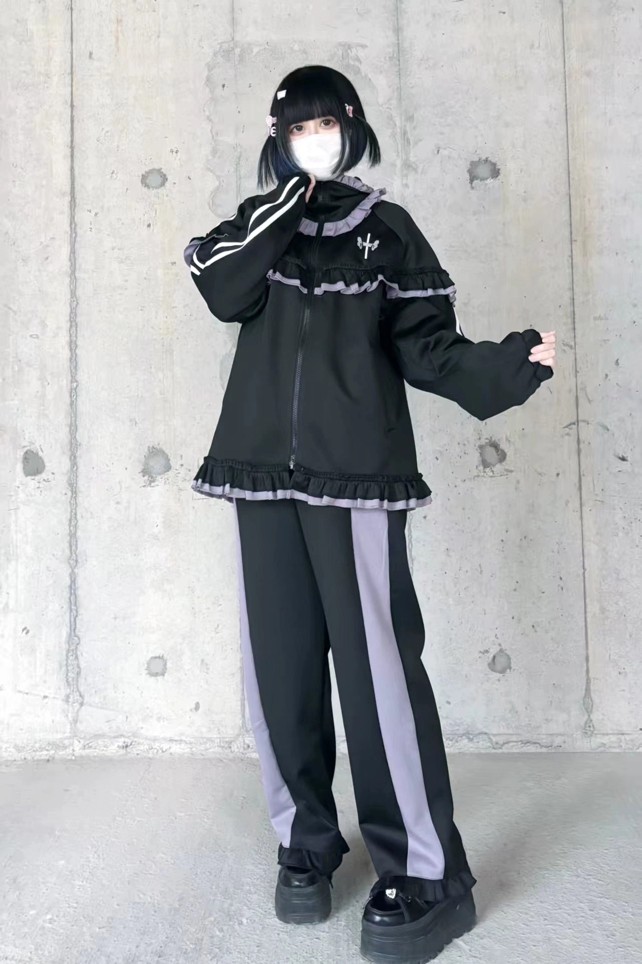 Black-purple ruffle Tenshi Kaiwai tracksuit with side stripe wide-leg pants, zip-up jacket, platform shoes full-body flat shot concrete wall