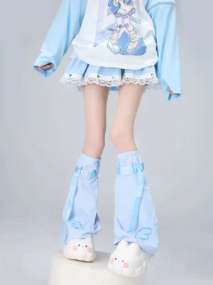 Light blue Tenshi Kaiwai flared leg warmers with cloud embroidery and blue ribbon straps, showcasing celestial aesthetic on female model studio background
