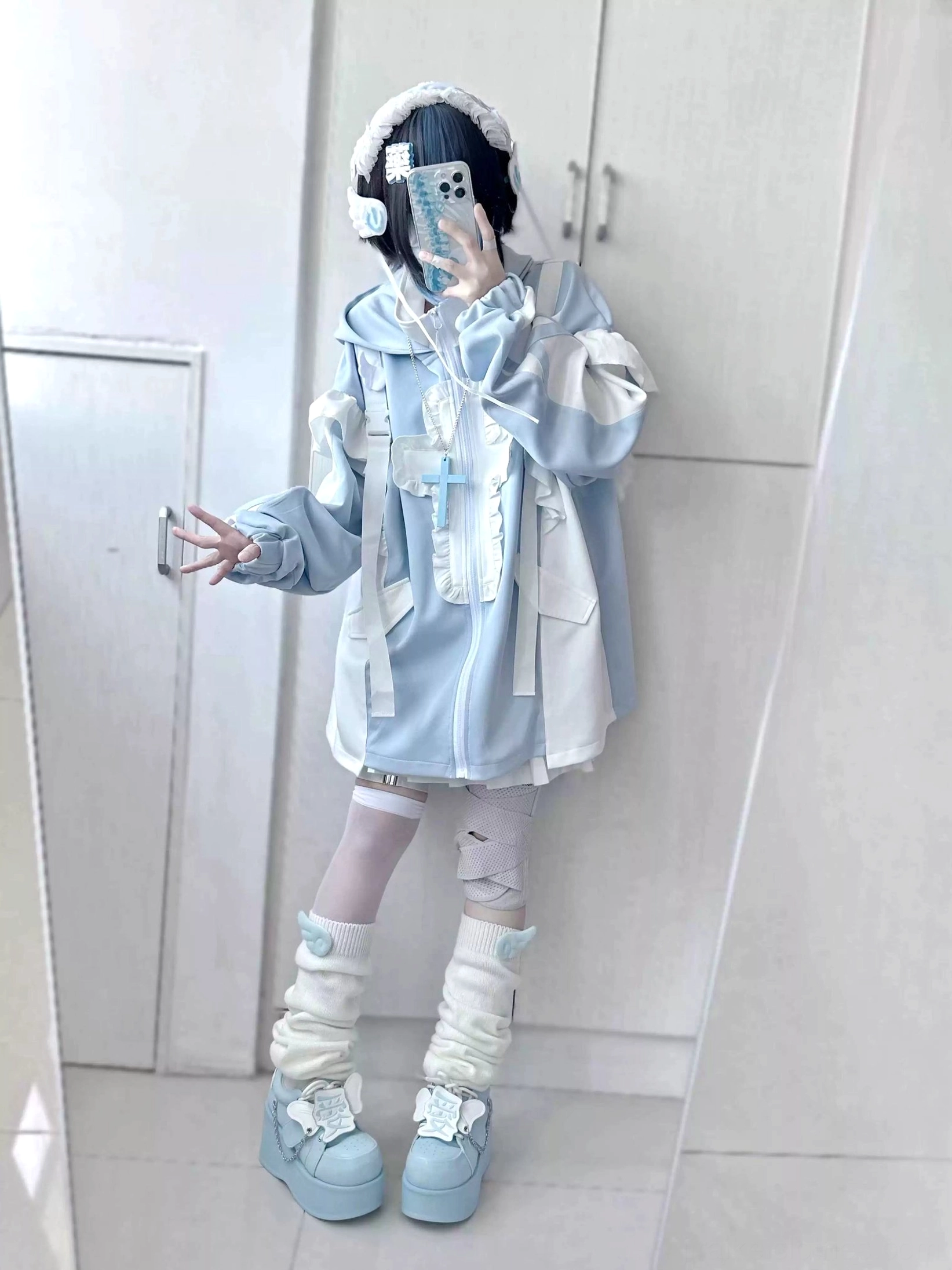 Front full-body view of pastel blue cat ear tenshi coat with earmuffs accessory, cross decorative details, bandaged leg styling and coordinated light blue leg warmers