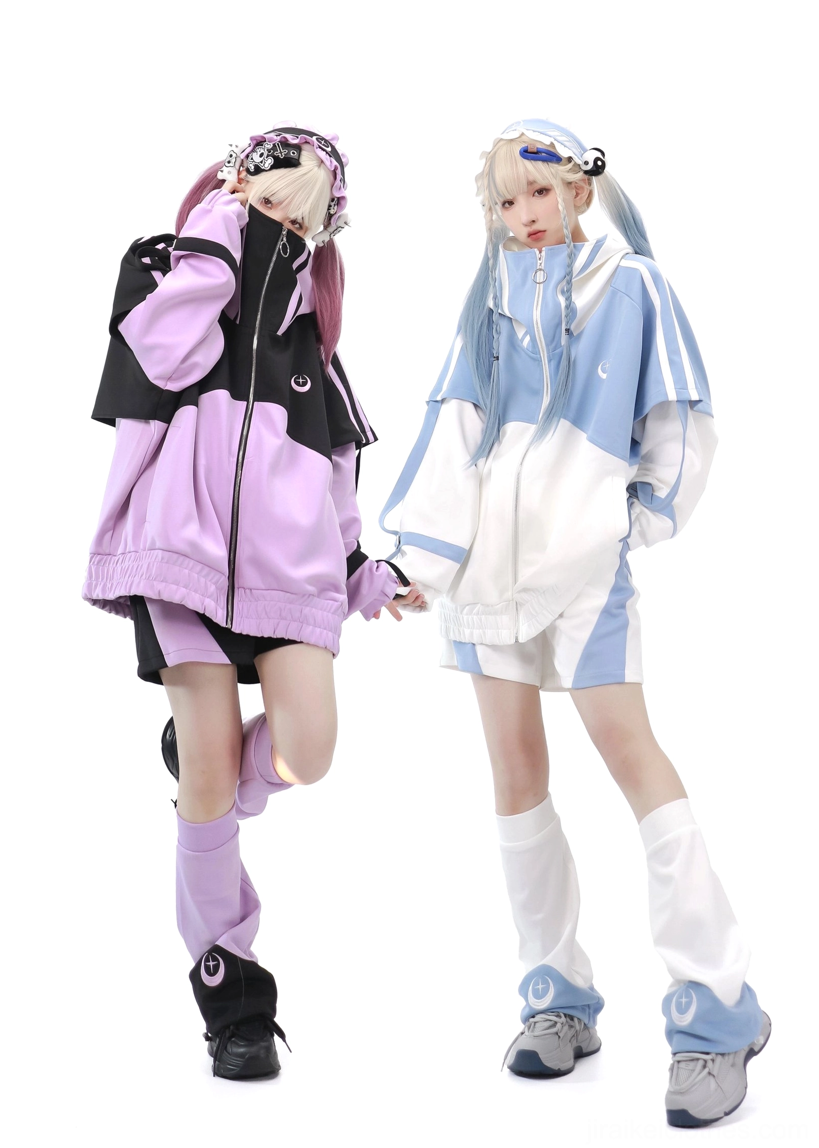Tenshi Kaiwai oversized sports set three-quarter rear view showing jacket and black shorts with matching crescent leg warmers on two blonde models with backpack prop in white studio