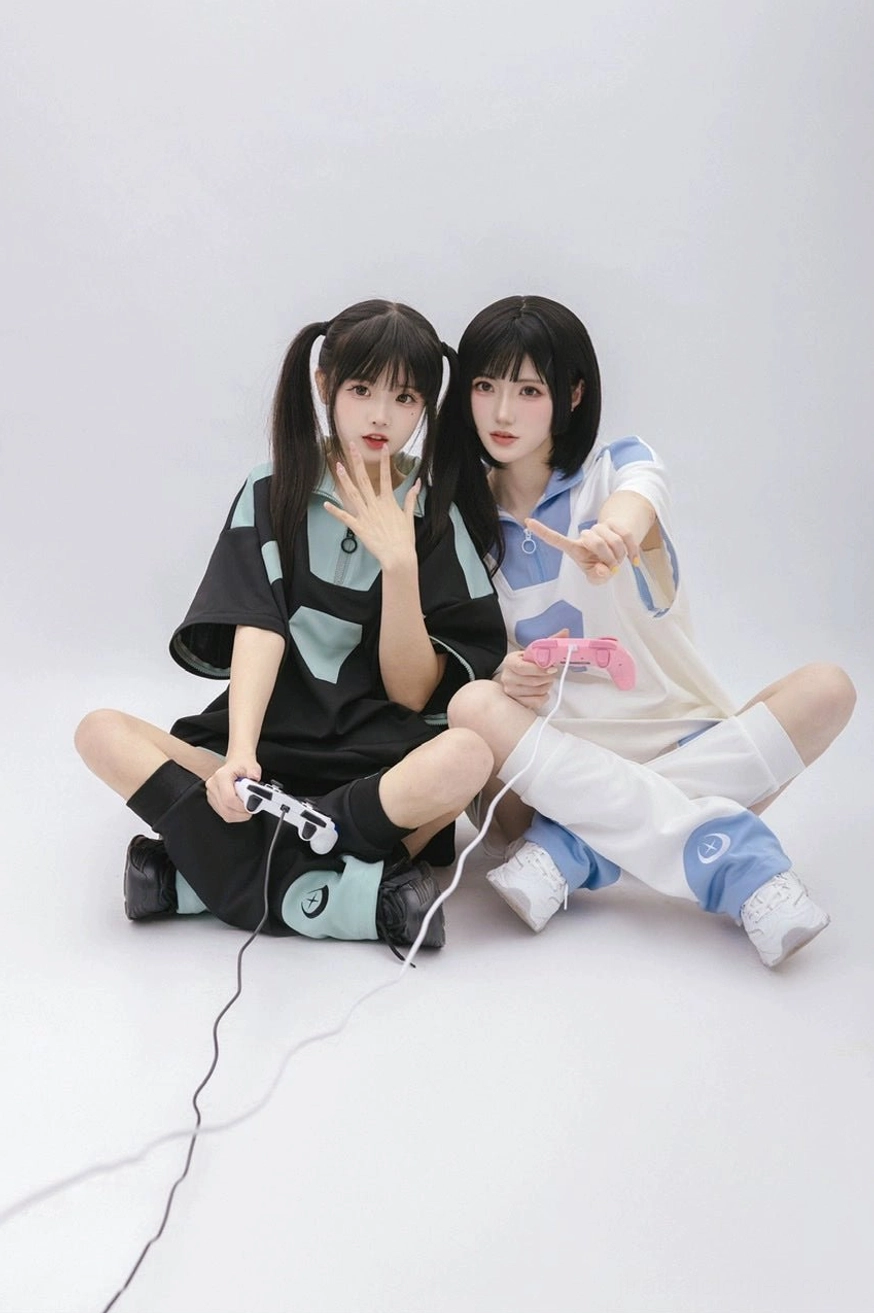 Overhead sitting view of casual Tenshi Kaiwai gaming wear set with two models on floor, multiple game controller props and relaxed coordinate styling