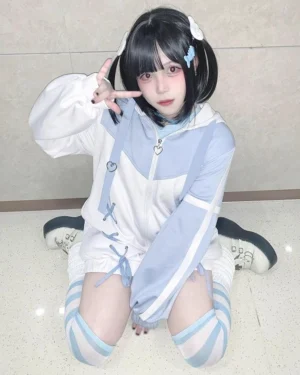 Blue-white Tenshi Kaiwai lace-up hooded sport jacket with contrasting color blocks, cross-lacing detail, and matching leg warmers on model wearing twin-tails