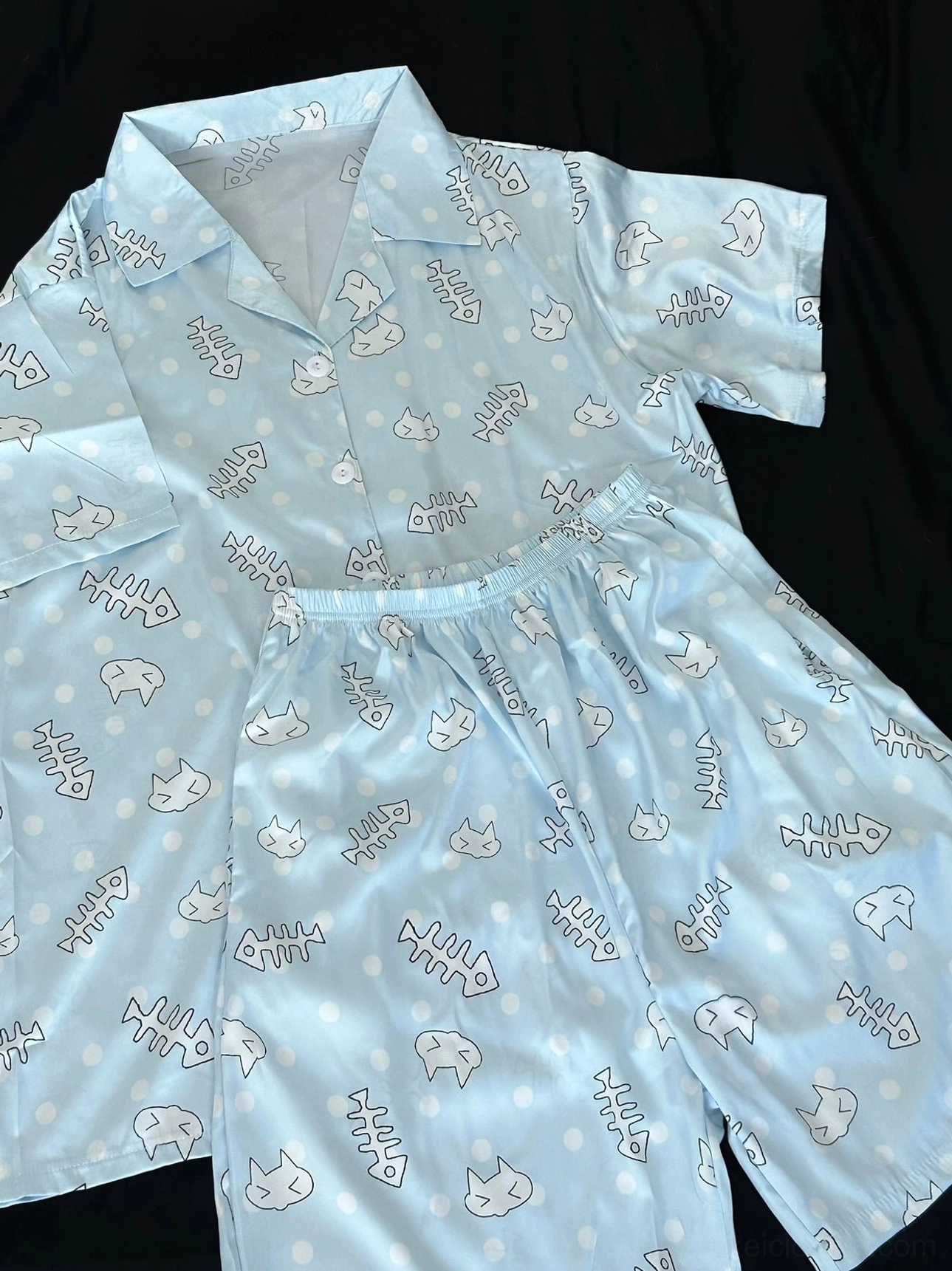 Tenshi Kaiwai light blue cat print short-sleeve pajama set with matching pants, flat lay perspective on black background displaying full outfit styling