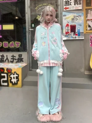 Pastel light blue Tenshi Kaiwai ruffle collar zip-up coat and pants set worn by model with pink hair in full front view showing white pom-pom trims kawaii angel aesthetic outfit