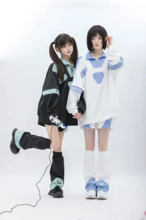 Dynamic standing view of matching Tenshi Kaiwai two-piece sporty set with one model lifting leg, featuring game controller prop and coordinating leg warmers