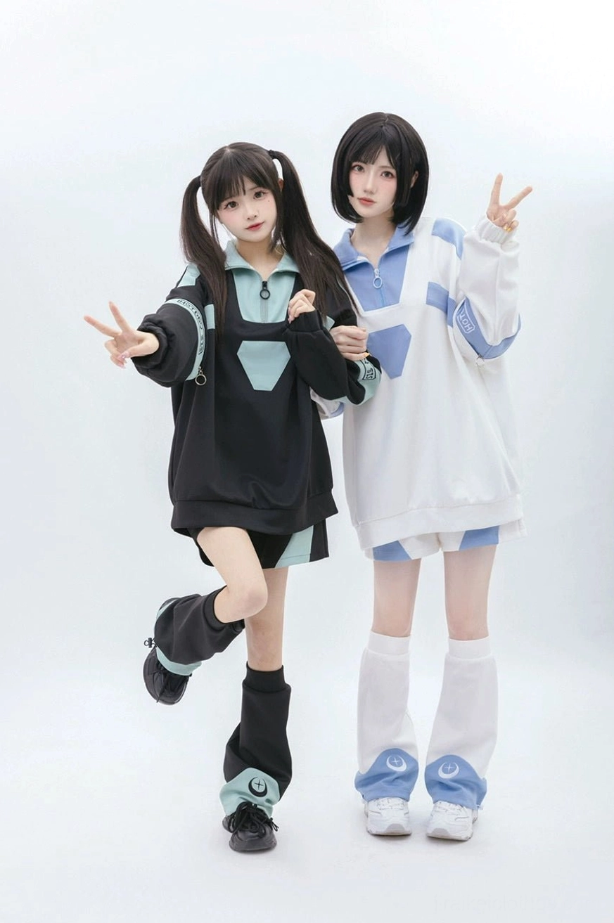 Full-body playful standing view of oversized Tenshi Kaiwai sportswear set with two female models making peace sign poses, wearing loose leg warmers