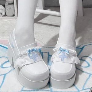 Tenshi Kaiwai platform high heel shoes white glossy with blue cross heart bow and lace trim overhead close-up worn with white thigh-high socks Jirai Kei aesthetic