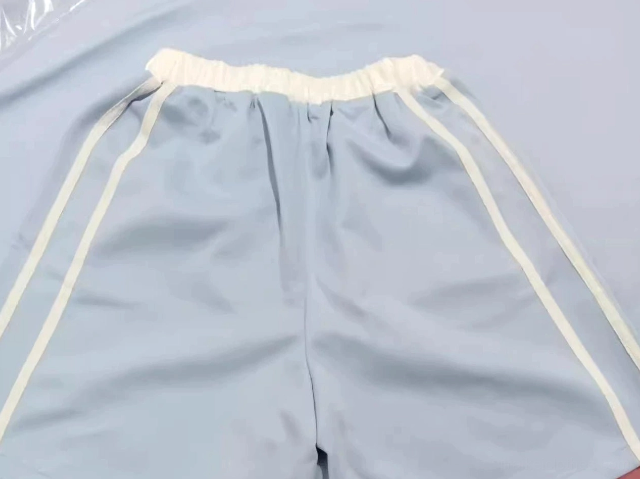 Pastel blue and white striped shorts from Tenshi Kaiwai collection with elastic waist shown on two models