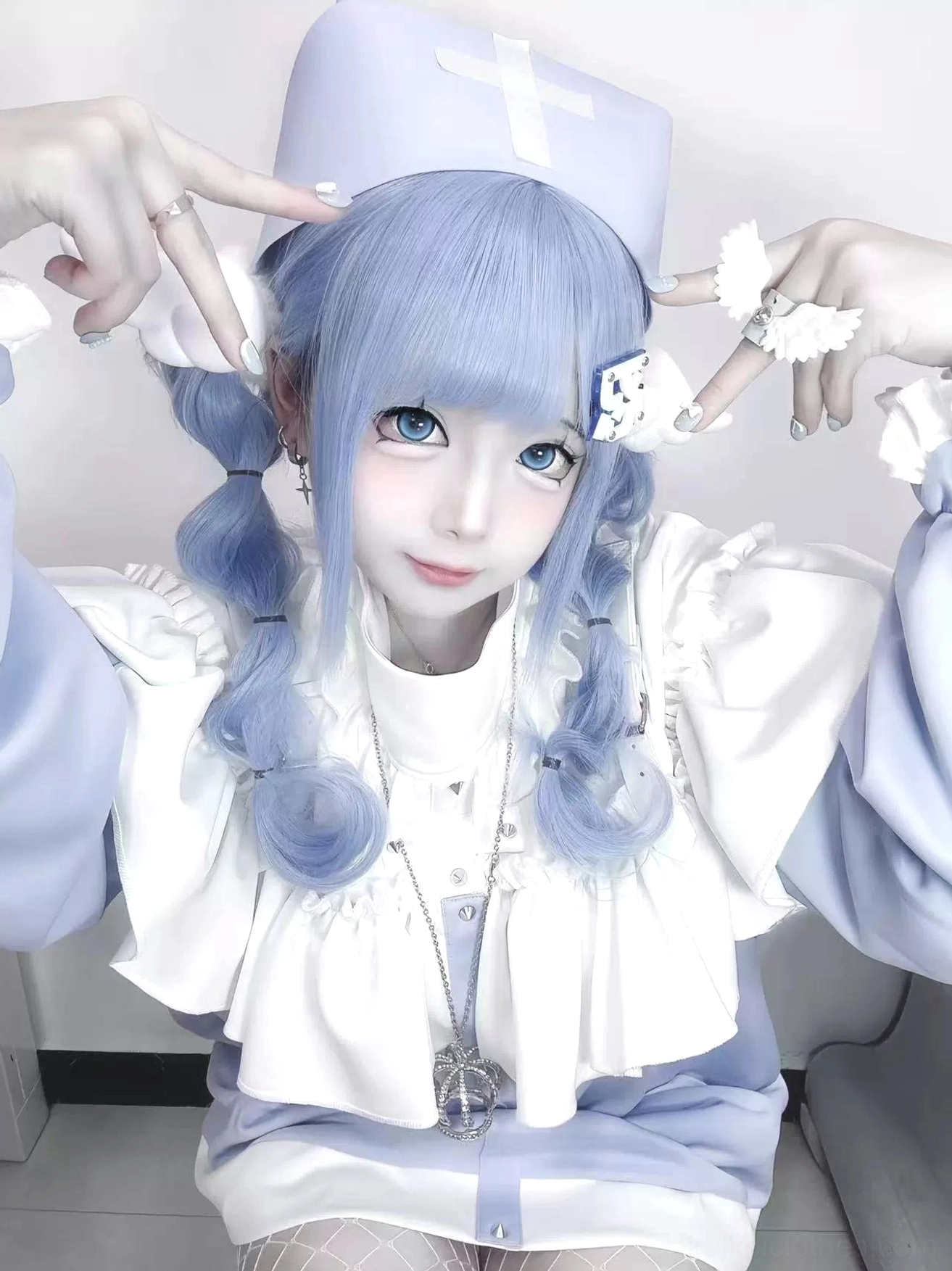 Close-up detail shot of Tenshi Kaiwai sweatshirt featuring layered white ruffled collar and silver cross necklace jewelry
