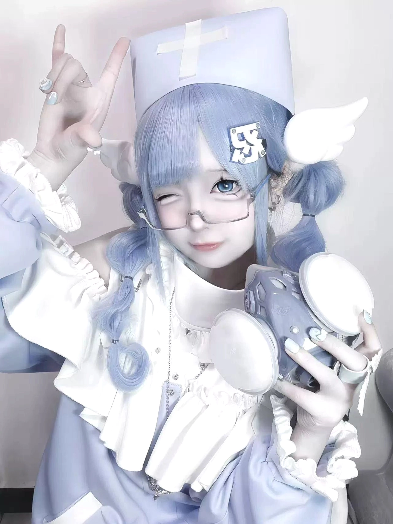 Close-up frontal portrait of Tenshi Kaiwai model with toy camera and cross-patterned nurse hat accessory detail