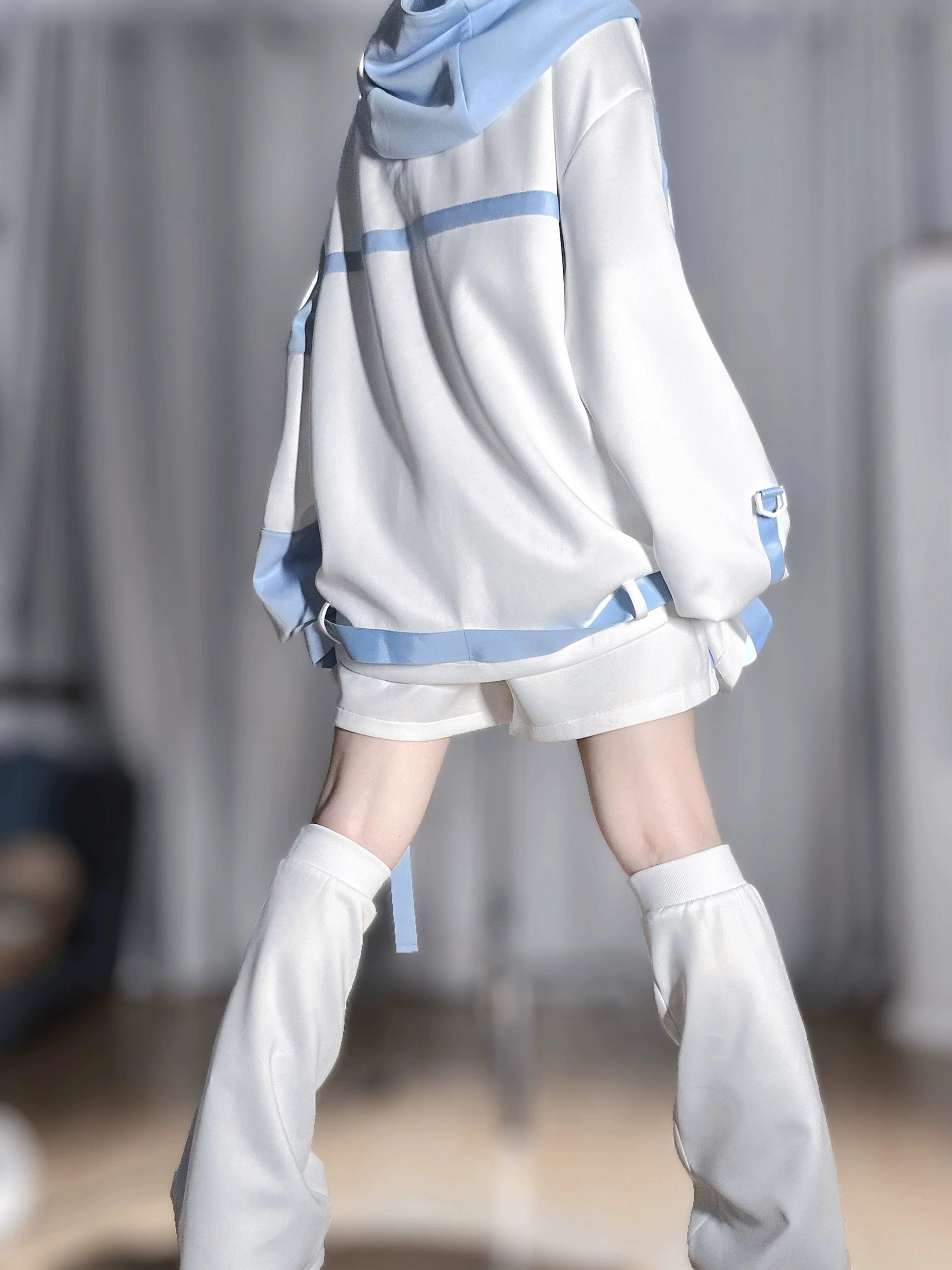 Tenshi kaiwai techwear outfit rear full view showing blue hood lining, matching shorts with hanging strap details, and coordinated leg warmers on model