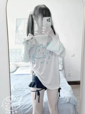 Tenshi Kaiwai cover-up blouse back view in mirror selfie styling with dark ruffled shorts and leg garters showcasing rear print placement and color-block design