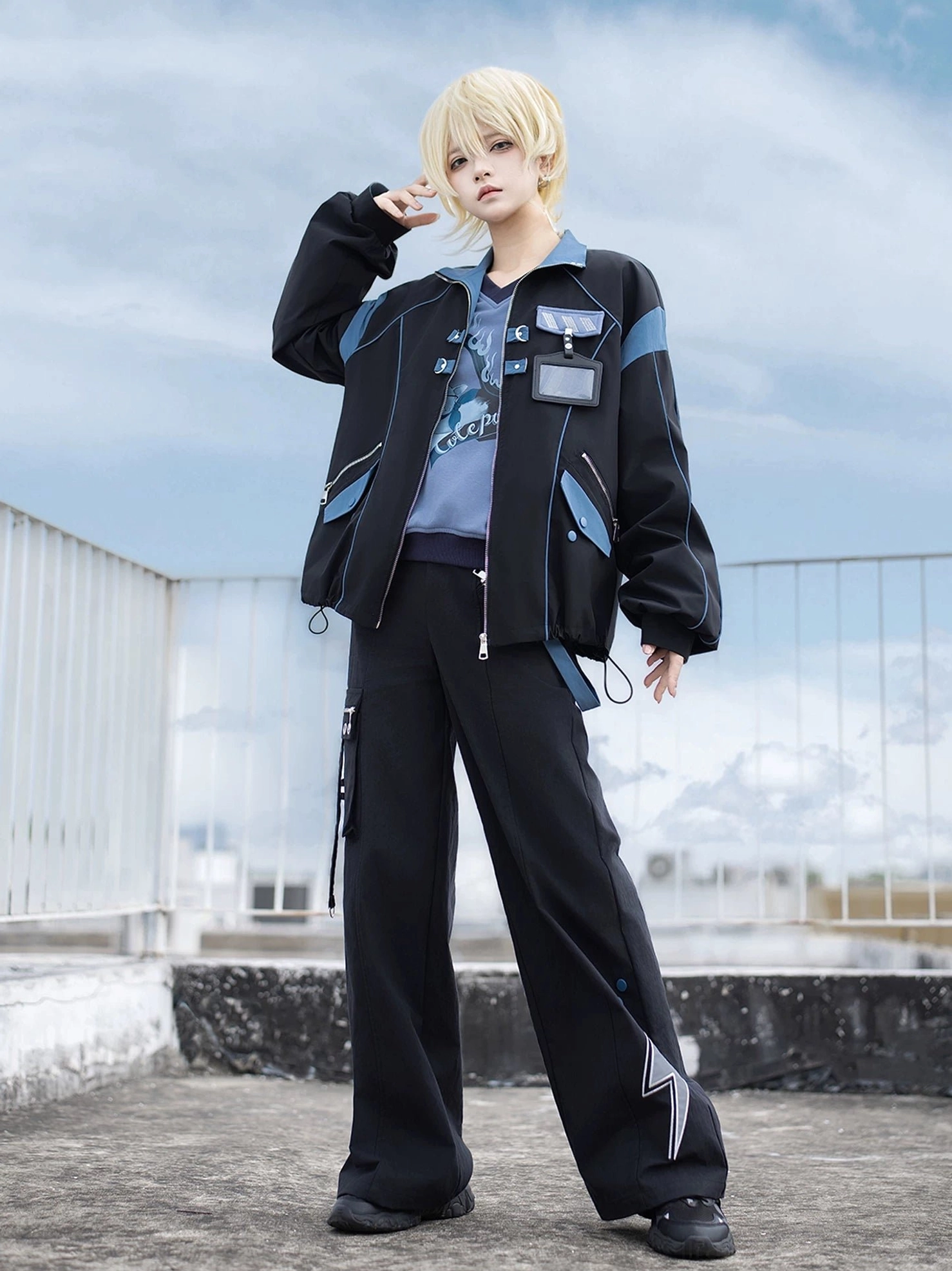 Front full-body model shot of Volt Cat Lightning Techwear Set with hand near face showing lightning stripe on pants leg