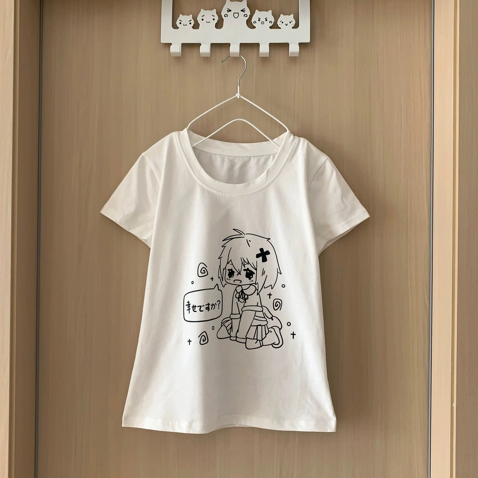 White anime graphic t-shirt hanging flat display showing round neckline short sleeves black line-art print