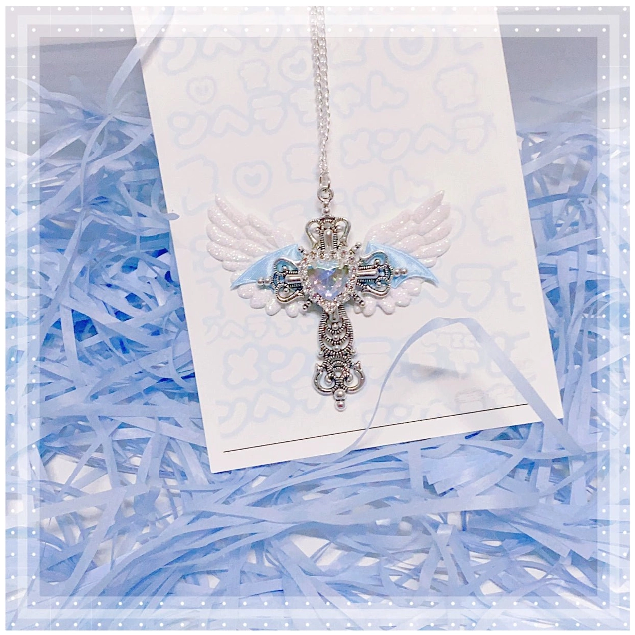 White and blue Y2K Jirai Kei angel wing cross necklace featuring clear heart centerpiece and silver cross on white heart mirror