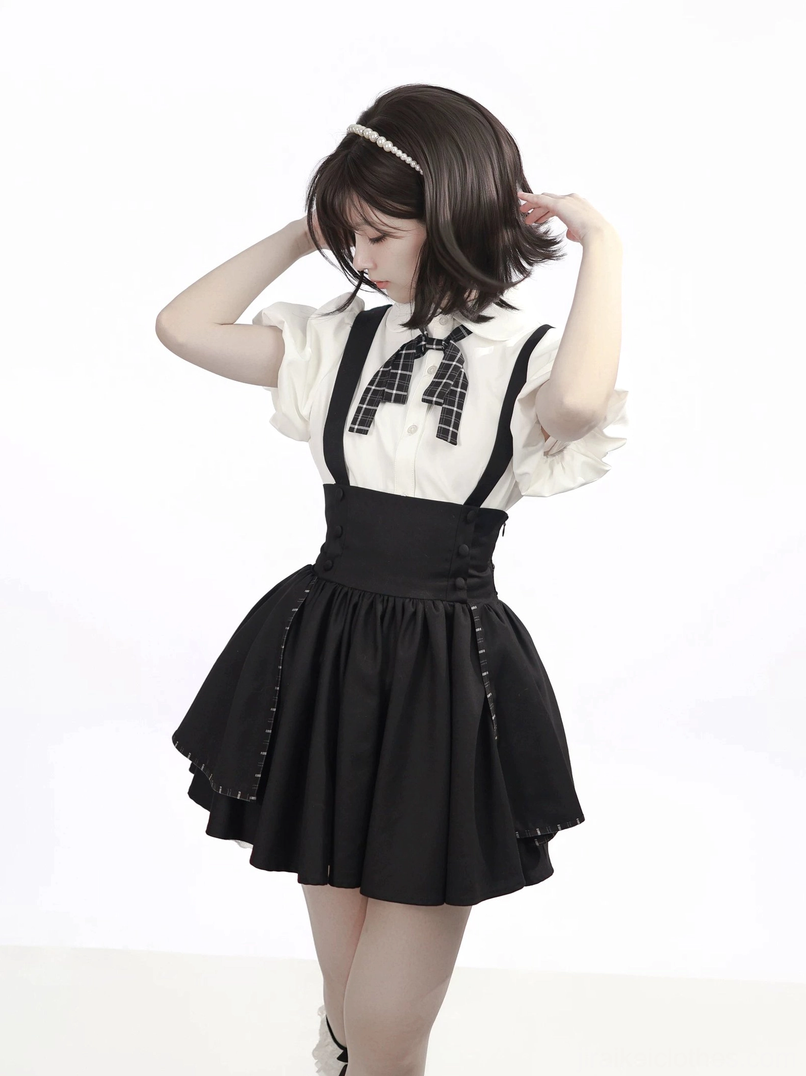 White puff sleeve bubble blouse with black suspender mini skirt full-body front view on model wearing plaid bow tie and black knee-high socks