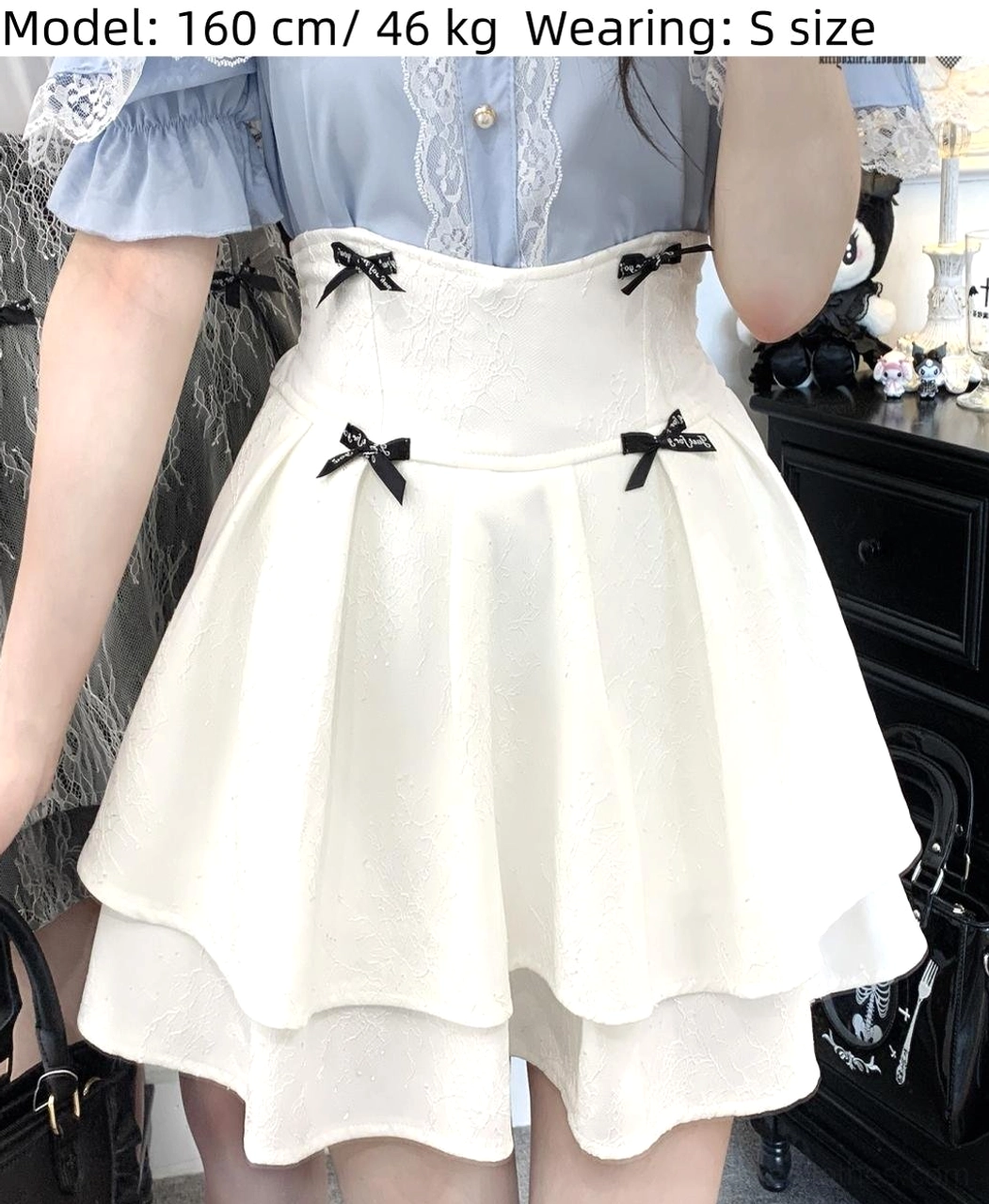 White double-layered lolita skirt upper body close-up on female model wearing size S, showcasing high waist design and black bow accents against vintage dresser backdrop