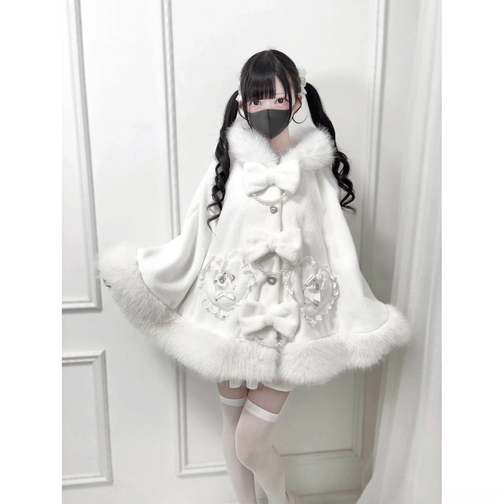 White faux fur Jirai Kei winter cape with floral embroidery and bow accents, front full body view on model