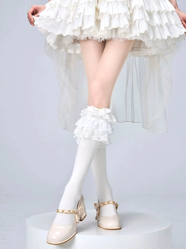 White frilly lolita calf socks with decorative lace ruffled cuff worn with crossed legs showing smooth knit texture and delicate details