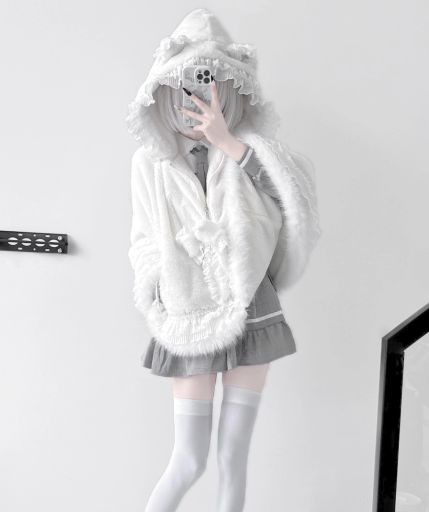 Close-up detail shot of white jirai kei cat ear fleece cape coat fabric texture, ruffle trim, and hood embellishment design elements
