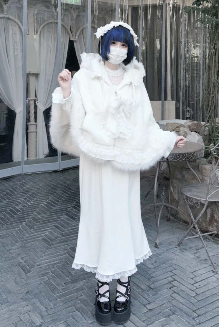Side profile of white jirai kei cat ear fleece cape hoodie showing cape drape, hood design, and plush texture under different lighting
