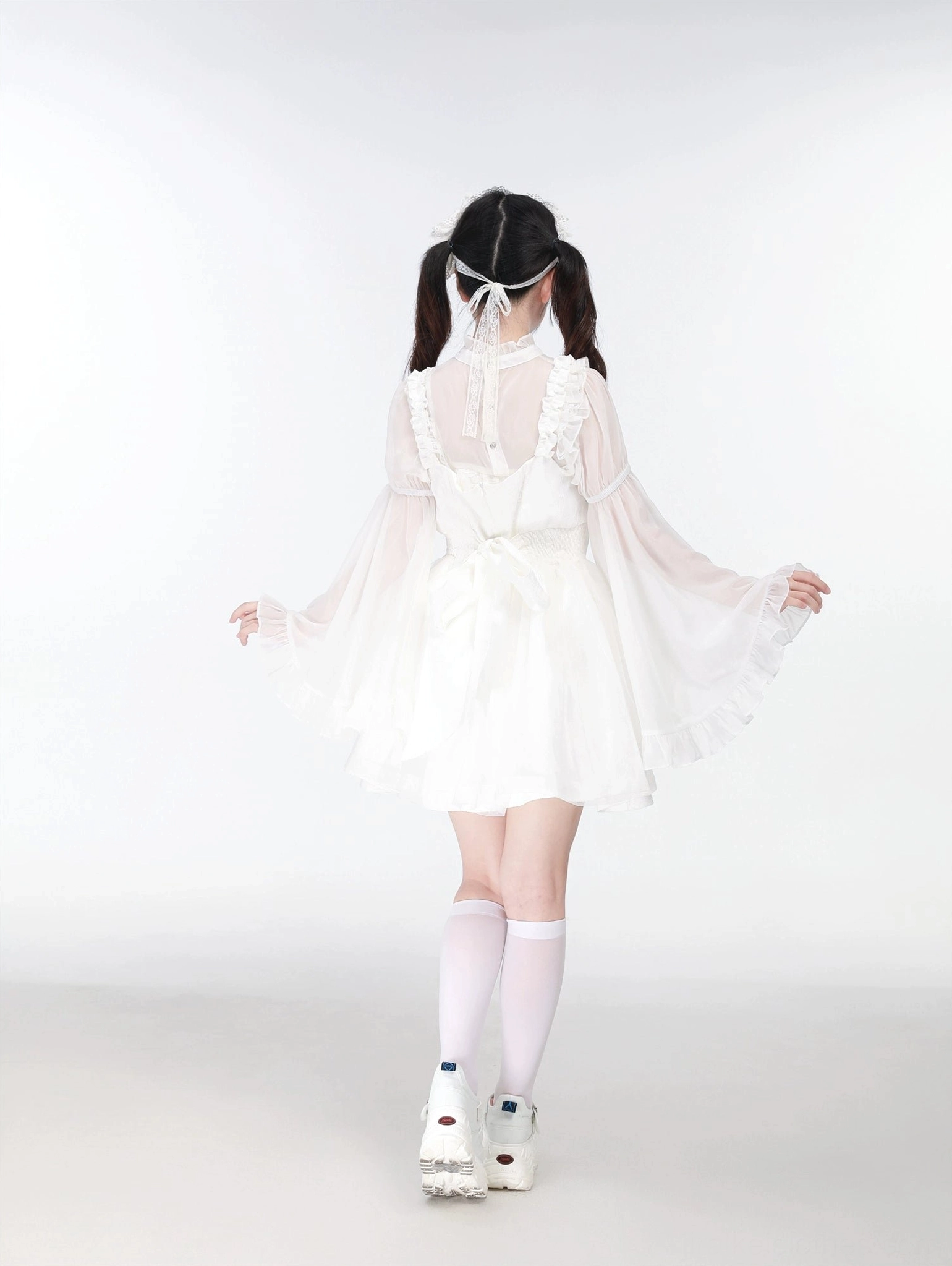 White Jirai Kei jumper dress back view sheer back panel large ruffled flare sleeves and white knee-high socks