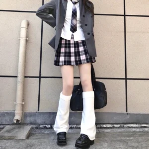 White over-knee jirai kei leg warmers with flared knit design worn by female model in JK suit aesthetic outdoor setting