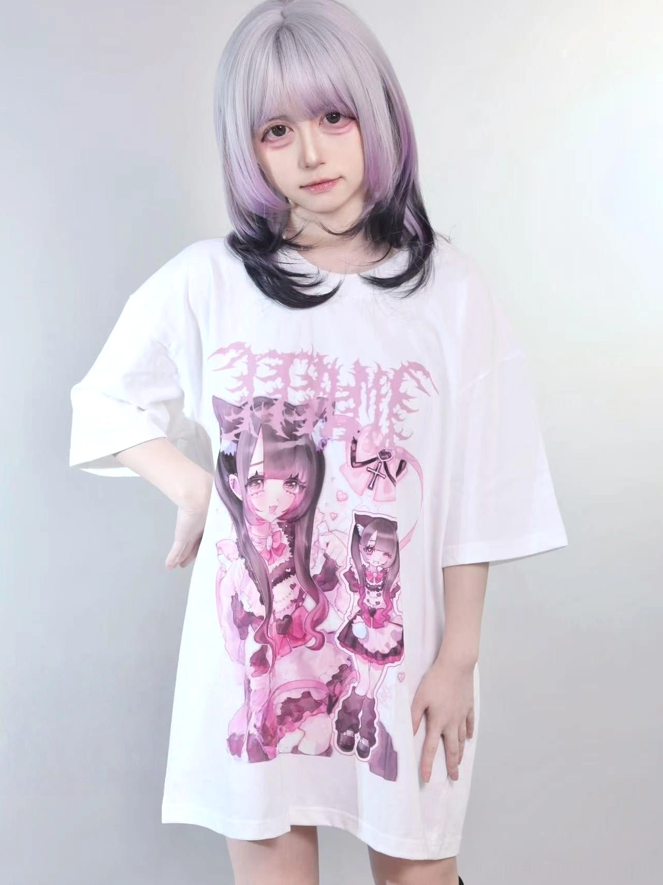 White jirai kei oversized maid graphic tee with model styled with two-tone purple and black wig, casual front angle shot, pink-purple gothic print design