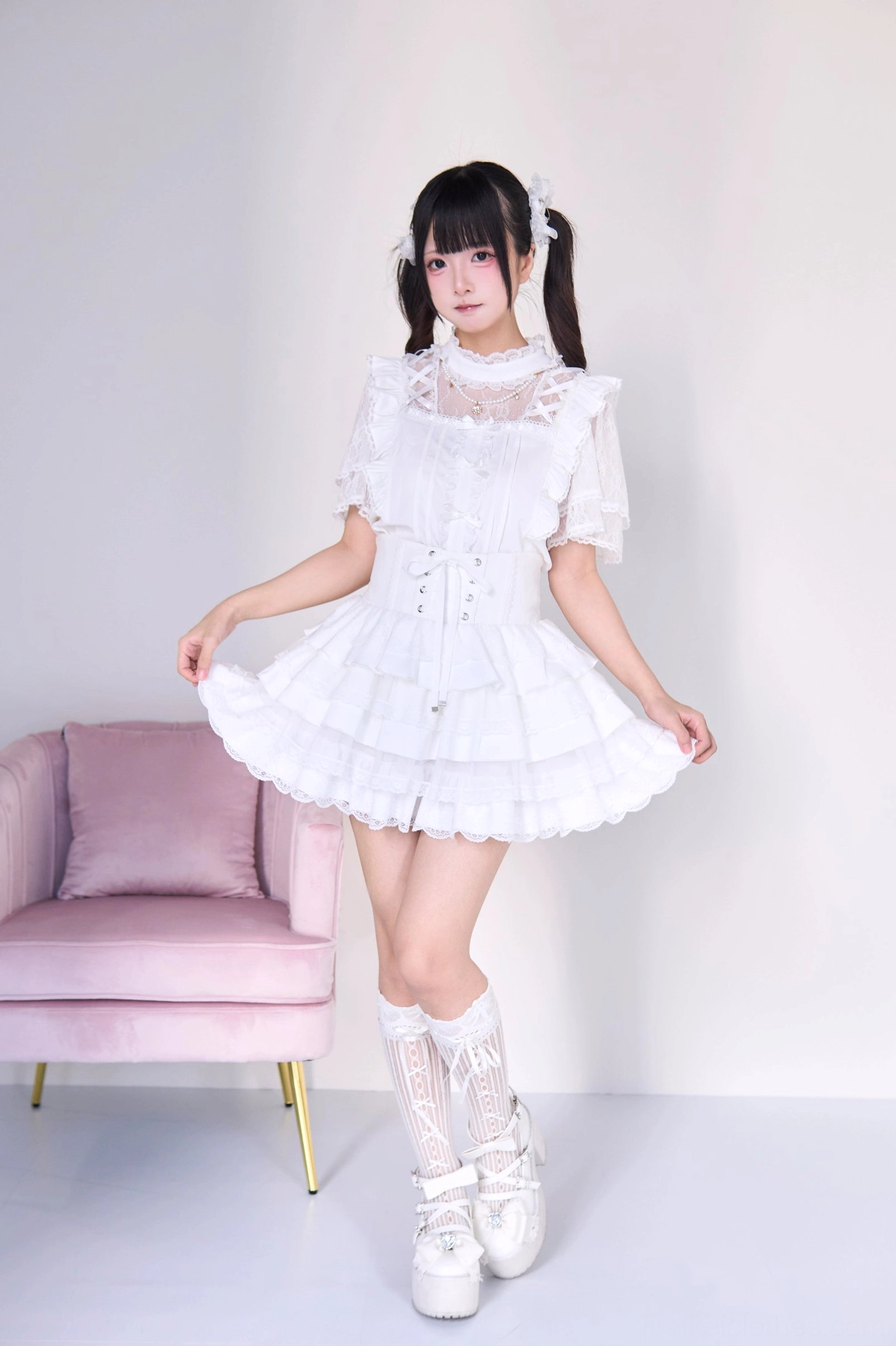 White gothic lolita jirai kei two-piece set with pearl necklace blouse and tiered cake skirt, front full-body shot featuring sheer lace yoke corset waist layered ruffles and white platform shoes