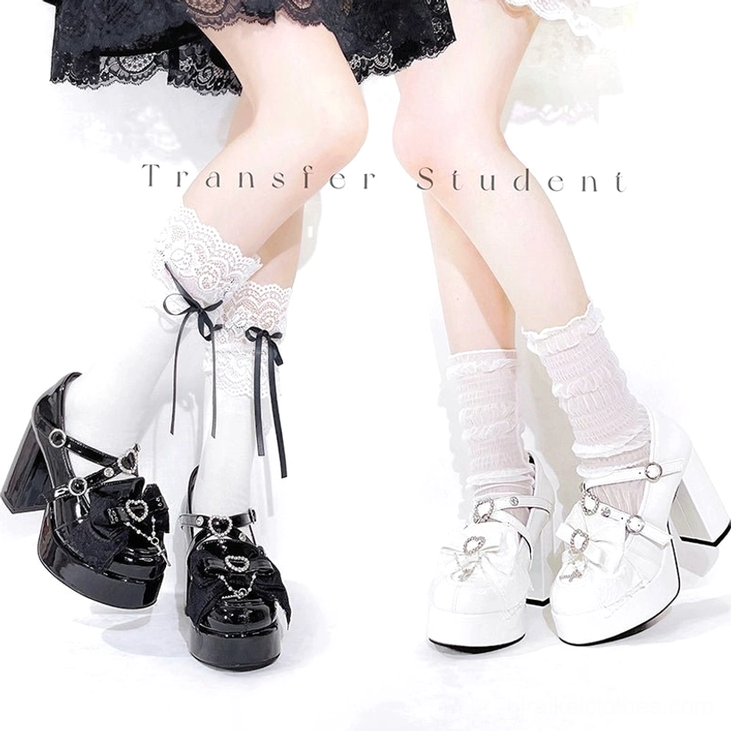 Full view of white Jirai Kei platform high-heel shoes with heart-shaped rhinestone hardware, adjustable buckle system, and glossy patent leather upper construction