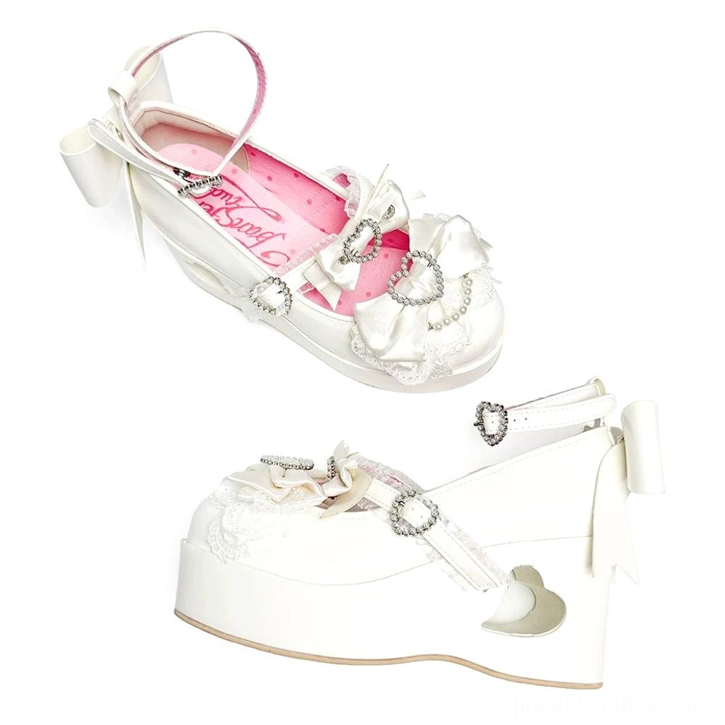 White Jirai Kei platform Mary Jane shoe displaying lace-trimmed bow detail, rhinestone buckles, and signature heart-shaped heel cutout