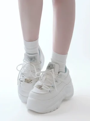 White matte jirai kei platform casual sneakers front three quarter view with white socks displaying chunky outsole and branded tongue tag