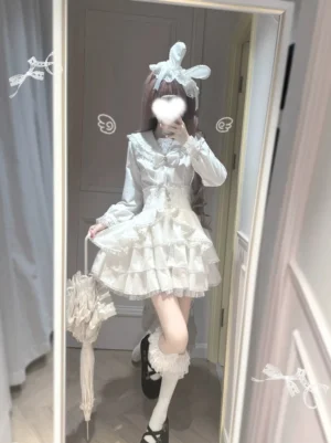 White Lolita Jirai Kei long-sleeve sailor blouse with fitted waist tiered ruffled skirt lace peter pan collar and detachable bow shown on model with bunny ear hair accessory holding lace parasol